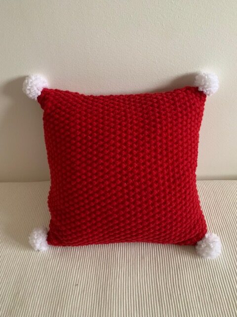 Dekorativni pletenijastuk sa pomponima crveni